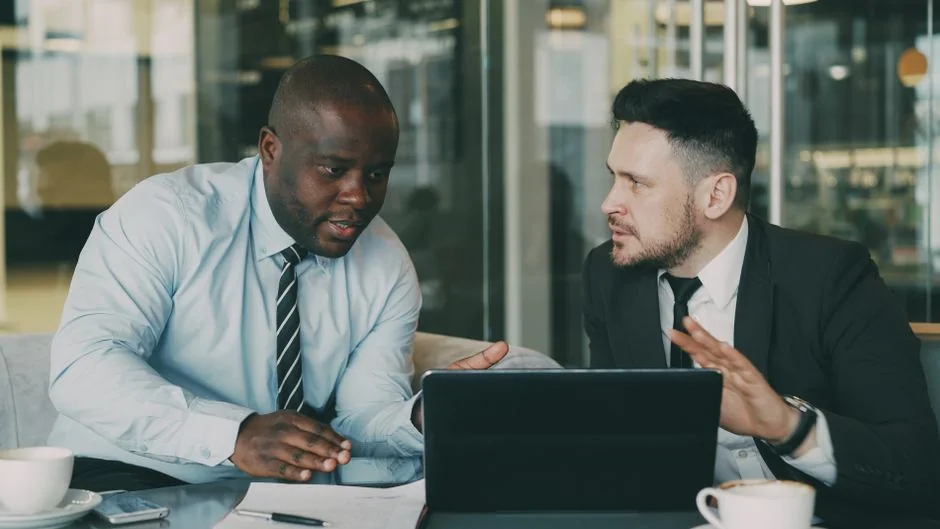Hands discussing marketing strategy with charts in an office setting.